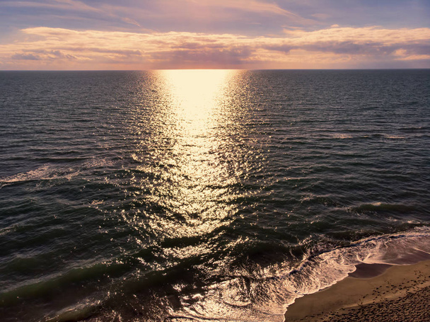 Vue aérienne du coucher du soleil sur l'océan, avec le reflet du soleil
  - Photo, image