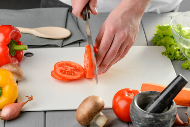 Man slicing a juicy tomato - Fotoğraf, Görsel