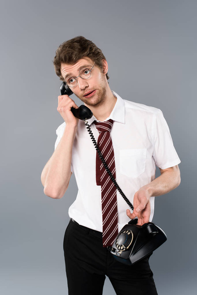 adult businessman in glasses talking on vintage phone isolated on grey - Foto, afbeelding