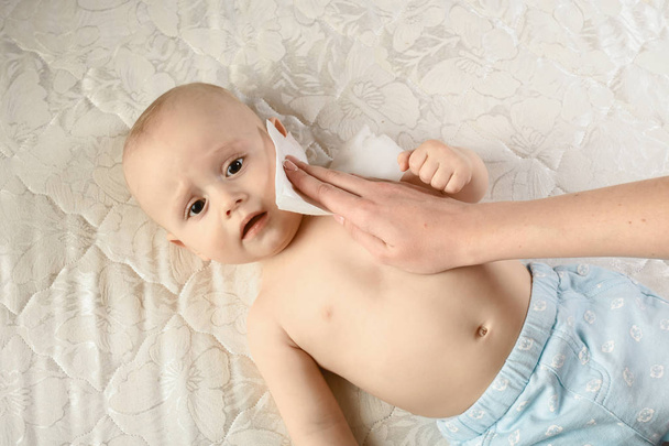 anyai gondoskodás a babának - nedves törlőkendővel törölje meg a baba bőrét. Vicces baba érzések. Gyermekgondozási higiénia. Tisztító törlőkendő, tiszta, tiszta - Fotó, kép
