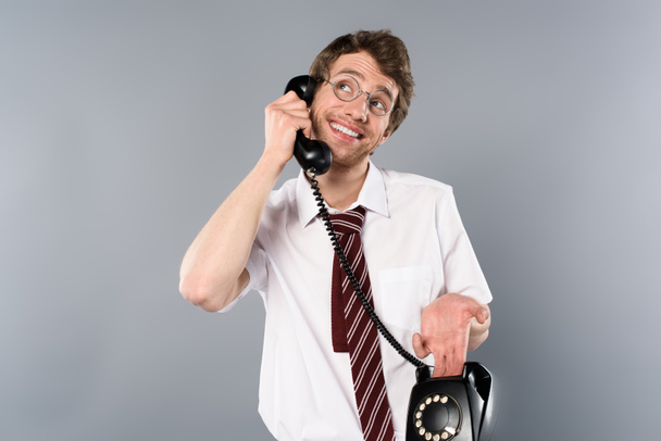 lachende positieve zakenman in glazen praten over vintage telefoon  - Foto, afbeelding