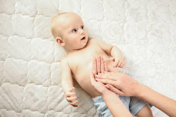 La madre fa il massaggio per bimbo felice, applica l'olio sulla mano, il concetto di Famiglia Felice. Bella immagine concettuale di Maternità
 - Foto, immagini