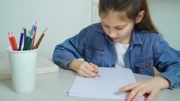 little girl in jeans wear drawing with colored pencil at home - Imágenes, Vídeo