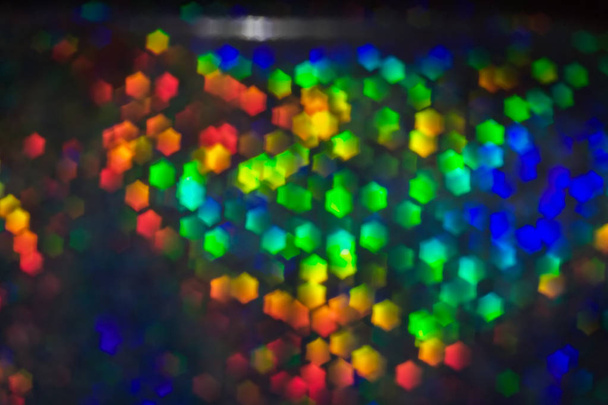 Πολύχρωμο εκτυφλωτικό φως στο σχήμα του ένα εξάγωνο. Αφηρημένα φόντο 3d. Κόκκινο, μαύρο, μπλε, κίτρινο, πράσινο φώτα λάμπουν - Φωτογραφία, εικόνα