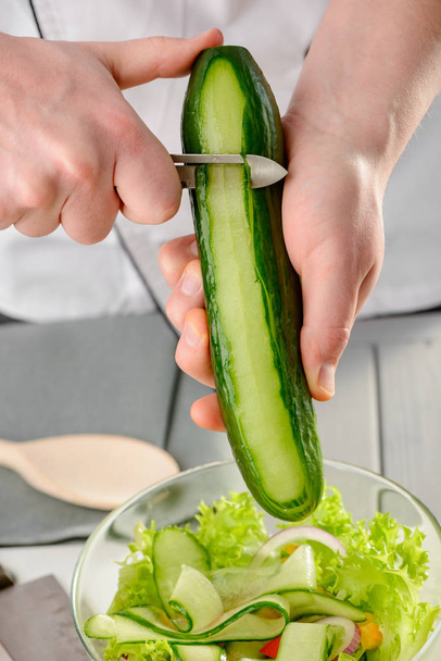 Man peeling a cucumber - Valokuva, kuva
