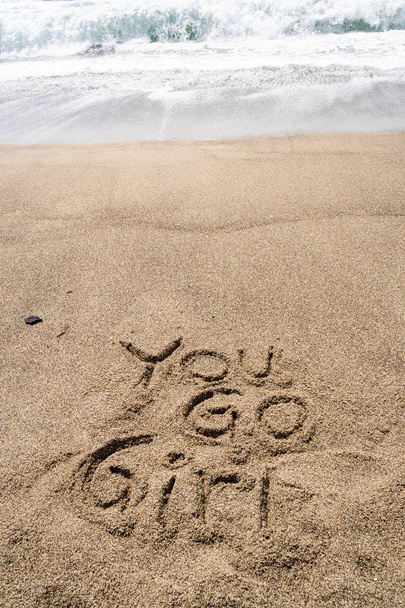 Popolare frase slang anni '90 You Go Girl scritta in sabbia sul becco
 - Foto, immagini
