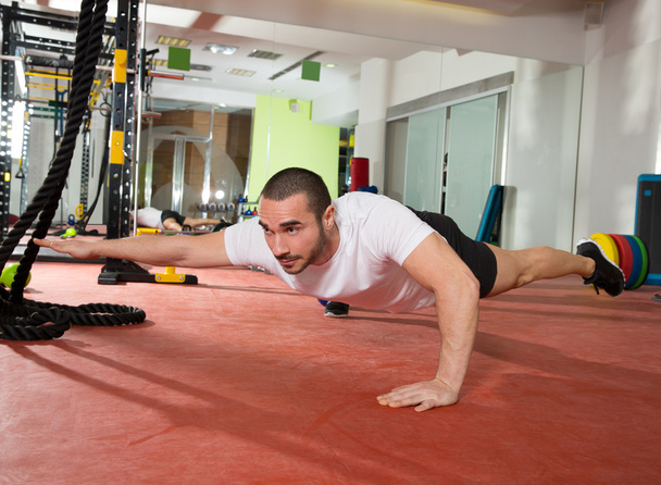 Crossfit fitness man balance pus ups with one leg and arm - Фото, изображение