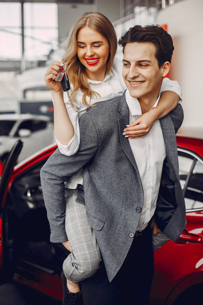 Elegant couple in a car salon - Foto, imagen