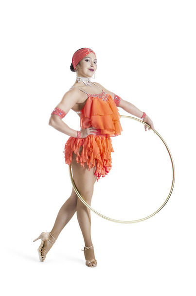 A girl in a stage dress performs a dance with a hula Hoop. - Foto, Bild