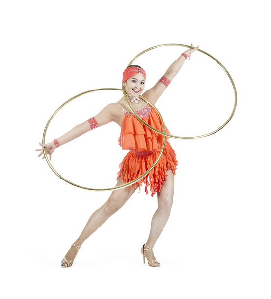 A girl in a stage dress performs a dance with a hula Hoop. - Fotó, kép