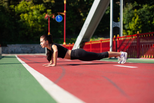 Full length side view of a beautiful athletic woman doing push u - Fotó, kép