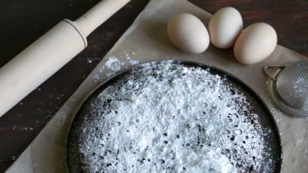 Homemade Baked Chocolate Brownie Muffin Powdered With Sugar Against A Background Of Eggs And Wooden Rolling Pin - Footage, Video