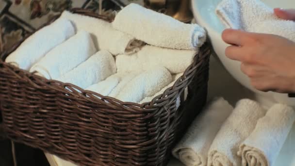 Mujer pliega toallas suaves limpias en la cesta, concepto de limpieza
 - Imágenes, Vídeo