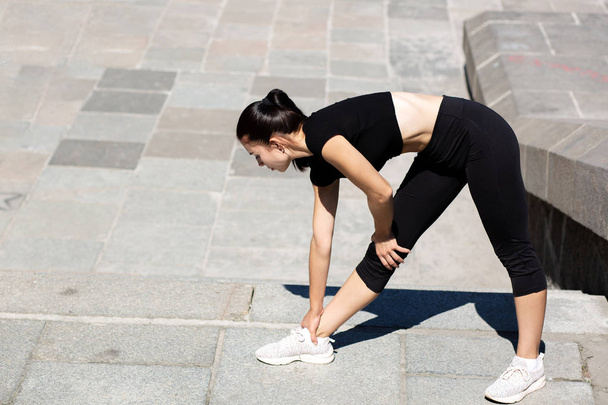 Amazing sporty woman wearing sport apparel stretching at the cit - 写真・画像