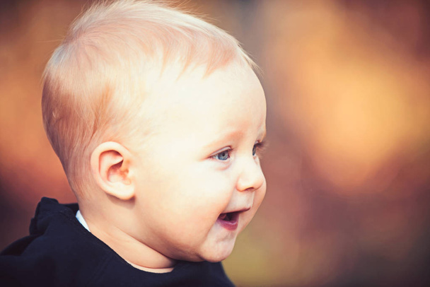 Baby boy smile on blurred nature. Little child with blond hair outdoor. Kid with adorable face. Happy childhood innocence and tenderness concept, copy space - Foto, Imagen