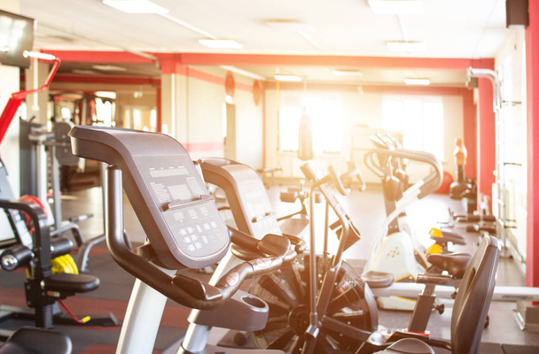 Gym interior with new sports equipment, treadmills and health, sun, background, running track, cardio - Zdjęcie, obraz