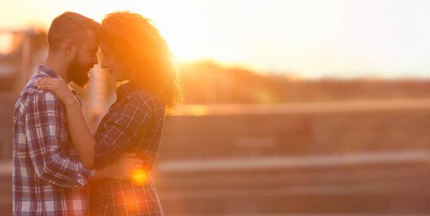 Couple romantique touchant le front contre le coucher du soleil de la ville
 - Photo, image