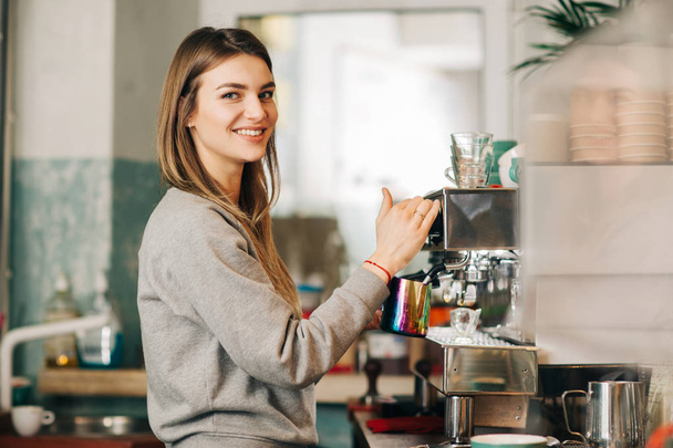 Ευτυχισμένος ξανθιά στη μηχανή του καφέ σε καφετέρια - Φωτογραφία, εικόνα