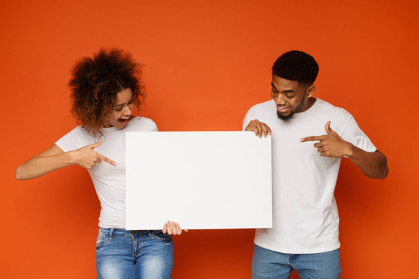 Young happy couple holding blank white board - Фото, зображення