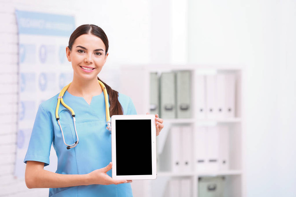 Portrait of medical assistant with stethoscope and tablet in hospital. Space for text - Foto, afbeelding