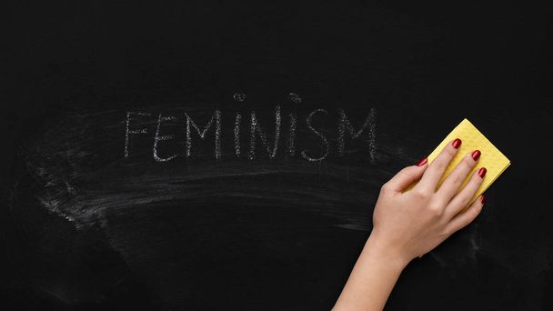 Nainen puhdistaa sanaa FEMINISM liitutaulussa, panoraama
 - Valokuva, kuva