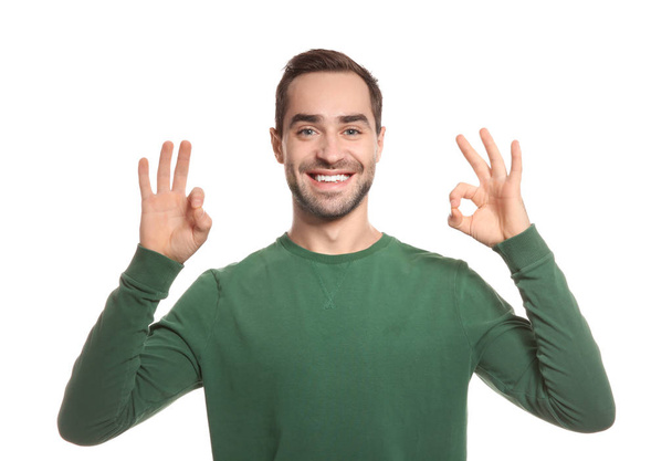 Man showing OK gesture in sign language on white background - Fotoğraf, Görsel