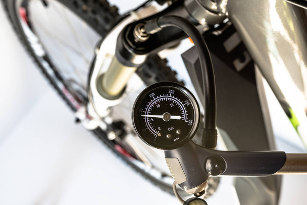 Szivattyúzás a front, kerékpár segítségével egy speciális szivattyú, a indikátor látható nyomás mértékegysége olaj-levegő lengéscsillapító bar / psi. - Fotó, kép