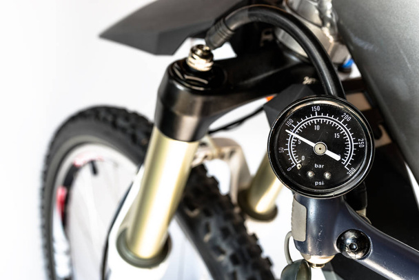 Pompage de l'avant, amortisseur huile-air vélo à l'aide d'une pompe spécialisée, indicateur de pression visible en bars / psi
. - Photo, image