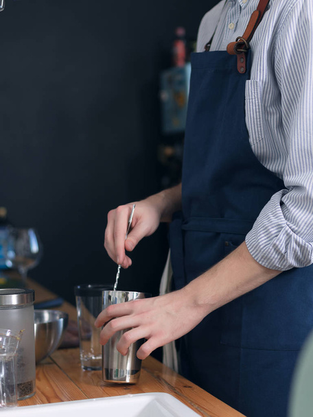 Barista maschio in grembiule blu in cucina a preparare cocktail
 - Foto, immagini