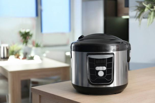 Modern multi cooker on table in kitchen. Space for text - Foto, imagen