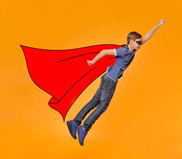 Junge in Maske und rotem Mantel fliegt wie ein Held - Foto, Bild