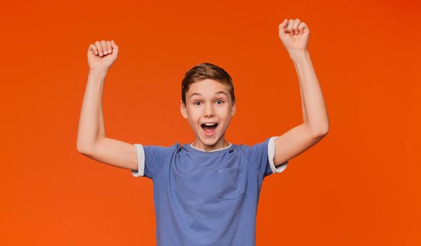 Joyful boy cheering, shouting with hands up - Foto, afbeelding