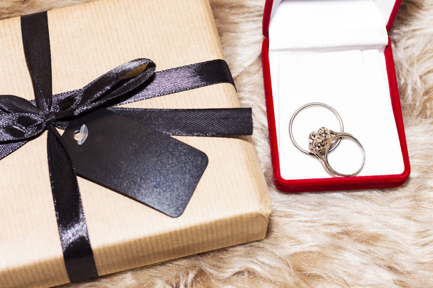 пропозиція шлюбу, обручка на червоній коробці і подарунок на свято
 - Фото, зображення