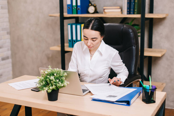 Female office worker viewing documents in workplace - Fotografie, Obrázek
