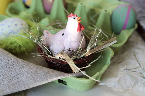 Chicken and quail eggs, toy chicken, hay, Easter decor on a light background - 写真・画像
