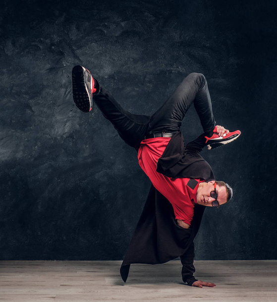 Stylowe facet wykonuje elementy akrobatyczne breakdance. - Zdjęcie, obraz
