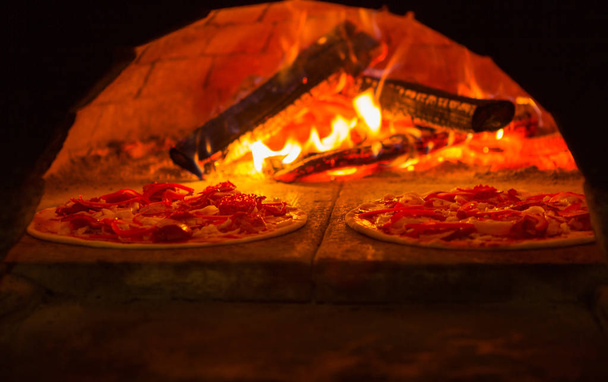 Italian pizza is cooked in wood-fired oven - Photo, Image