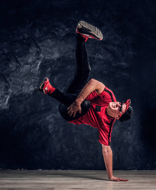 Tyylikäs kaveri suorittaa breakdance akrobaattisia elementtejä
. - Valokuva, kuva