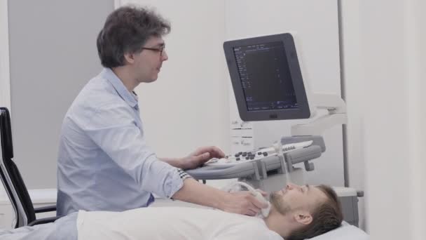 Médico haciendo diagnóstico por ultrasonido para paciente masculino
 - Metraje, vídeo