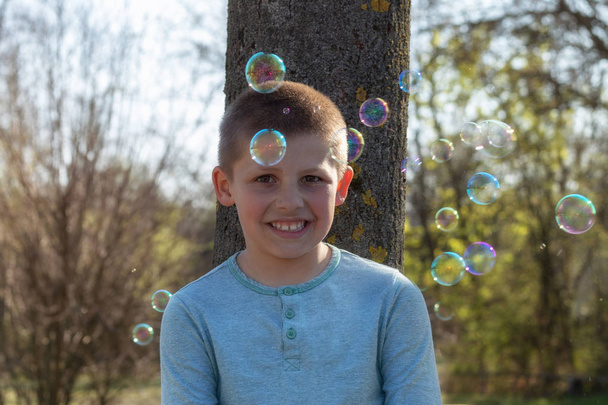Маленький милый мальчик, пускающий пузырьки в парке
 - Фото, изображение