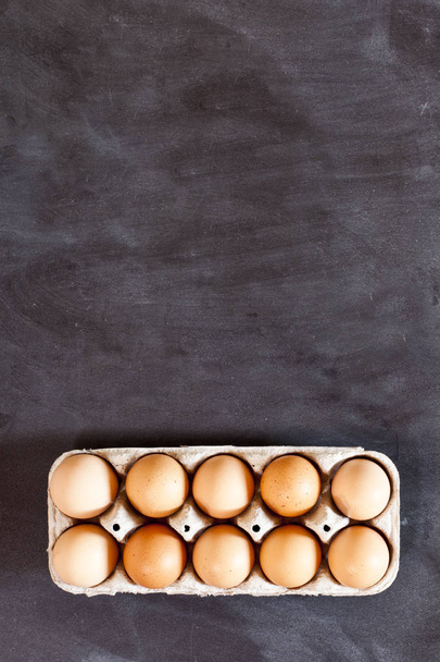 Farm chicken eggs in cardboard container. - Фото, зображення