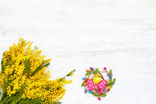 Velikonoční pozadí. Velikonoční dekorace a mimózy kytice na bílém - Fotografie, Obrázek