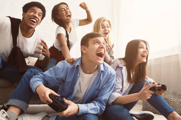 Ενθουσιασμένοι φίλοι που παίζουν βιντεοπαιχνίδια στο σπίτι - Φωτογραφία, εικόνα