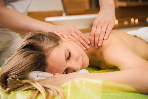 Vrouw genieten van klassieke massage van de nek- en schouderklachten - Foto, afbeelding