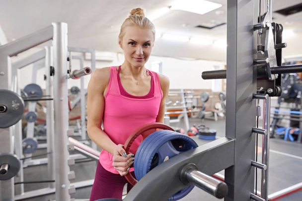 Young sporty blond woman in the gym. People fitness sport healthy lifestyle concept - 写真・画像