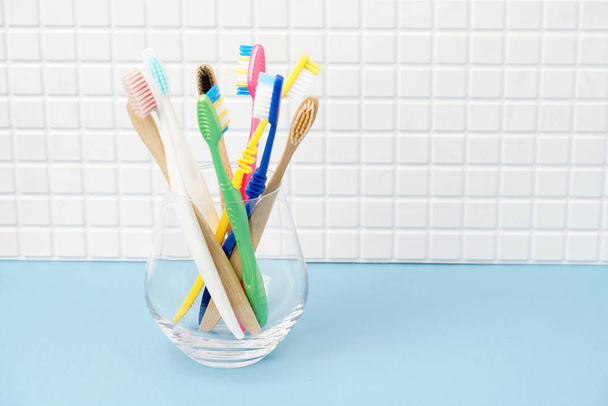 Toothbrushes in glass cup in bathroom - Φωτογραφία, εικόνα