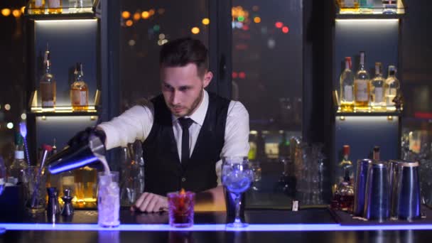 Bartender pouring ready cocktail drink in glass - Footage, Video
