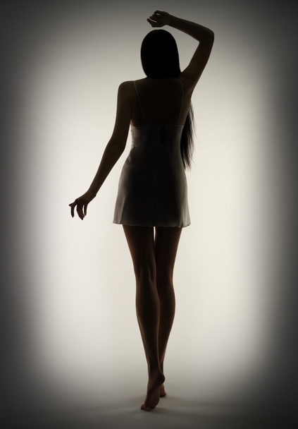 Silhouette of young girl on gray - Foto, Imagem