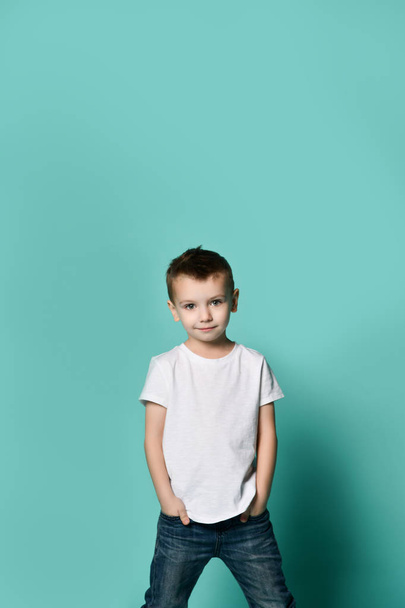 Little fashionable boy posing in front of blue wall. - Fotó, kép