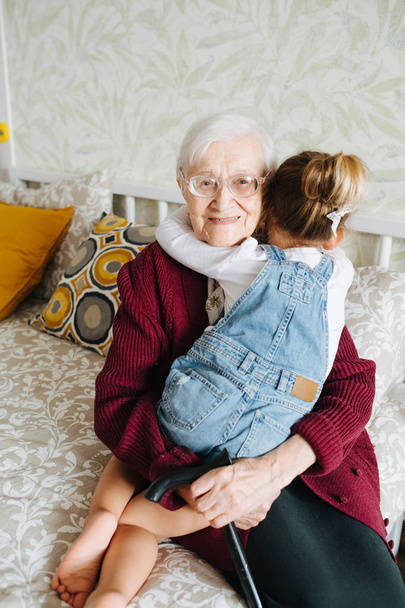 Happy moments. Little girl with her great grandma spending quality time together - Photo, Image